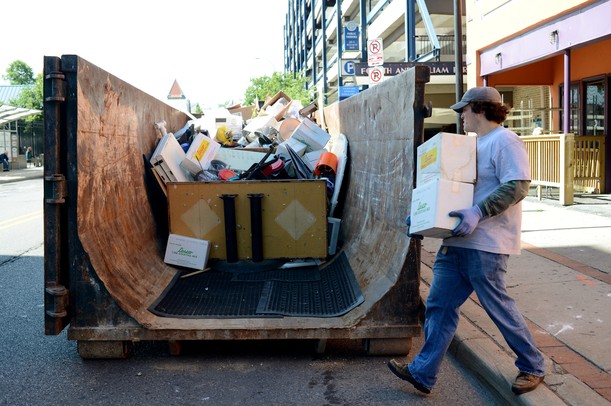 Tom Bianchi moves boxes of cocktail mix to a trash container as he works with a contractor to clear out the contents of the former Dream Nite Club on Monday morning. Melanie Maxwell I AnnArbor.com